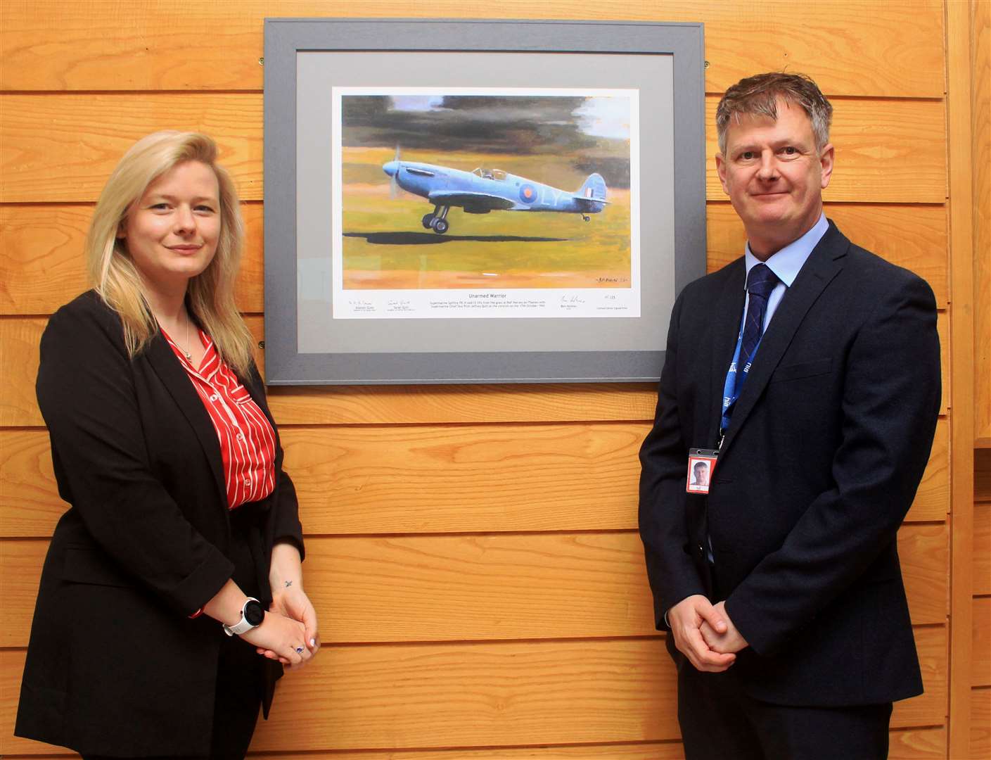 Onor Crummay, from the Spitfire AA810 restoration project, and Dougie Cook, north airports general manager at Highlands and islands Airports Limited, unveiled a limited-edition print of Spitfire AA810 by aviation artist Ben Holmes. Picture: Alan Hendry