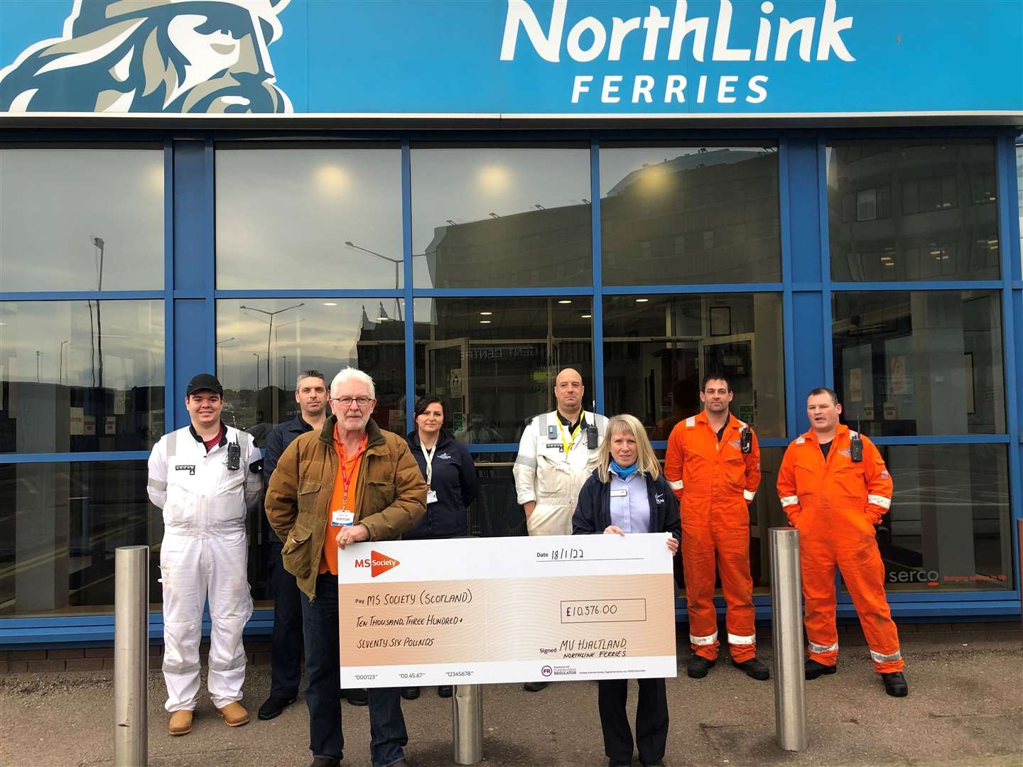 Kathryn Fullerton, shop manager and one of the main fundraisers at NorthLink Ferries, hands over a cheque to Mark Colley-Davies, community fundraiser at MS Society Scotland, accompanied by colleagues from NorthLink Ferries.