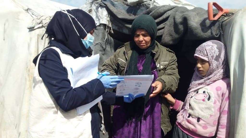 Community health workers helping to raise awareness of coronavirus in a refugee camp in northern Syria. Picture: SEMA