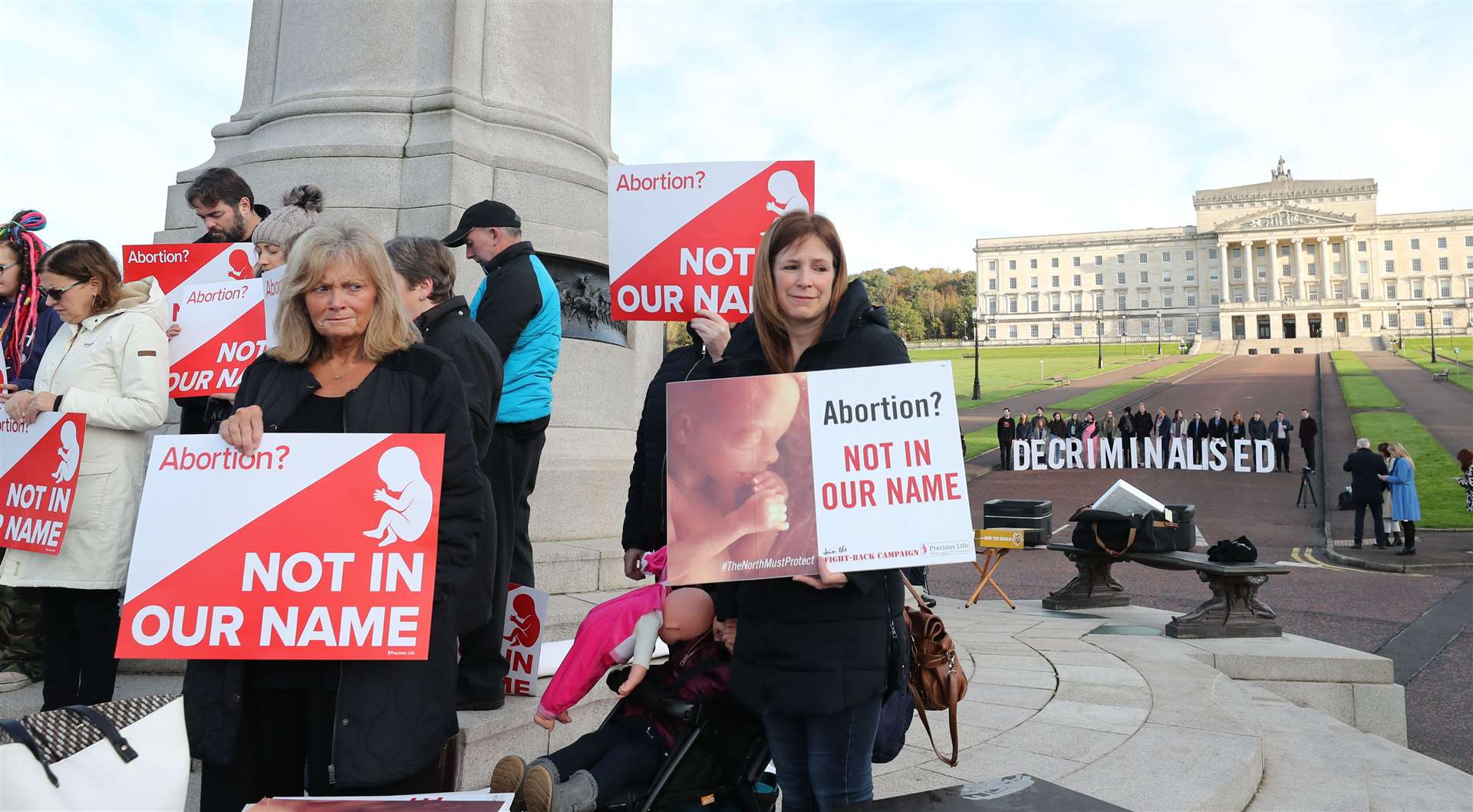 Anti-abortion and pro-choice activists take part in a photocall in the grounds of Stormont (Niall Carson/PA)