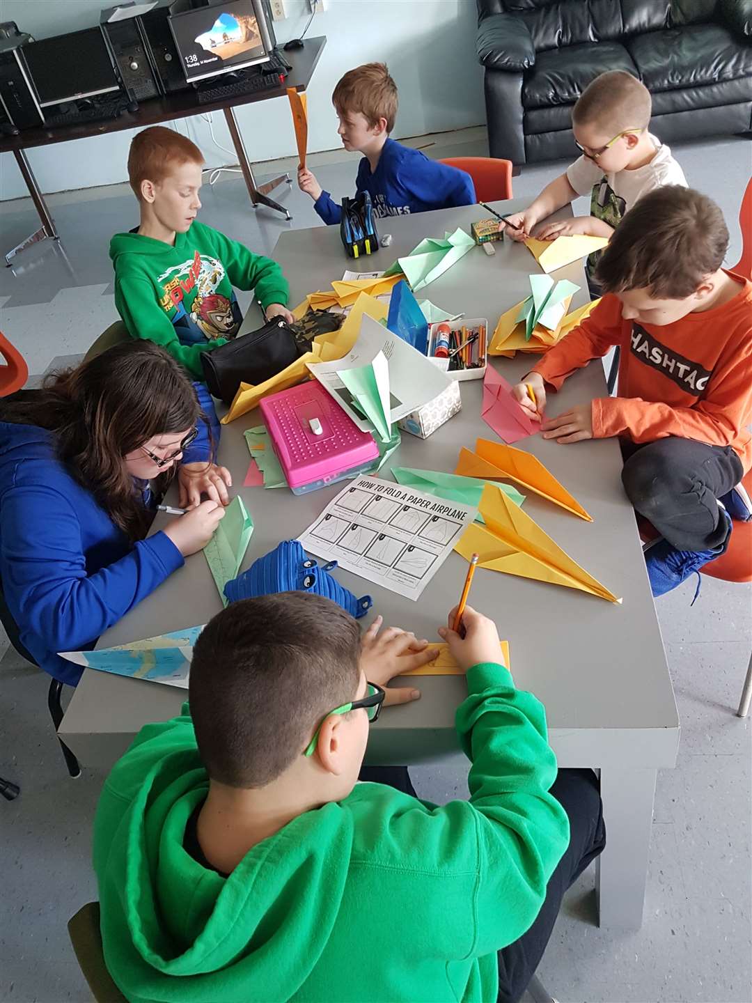 Cow Head kids making paper aeroplanes.