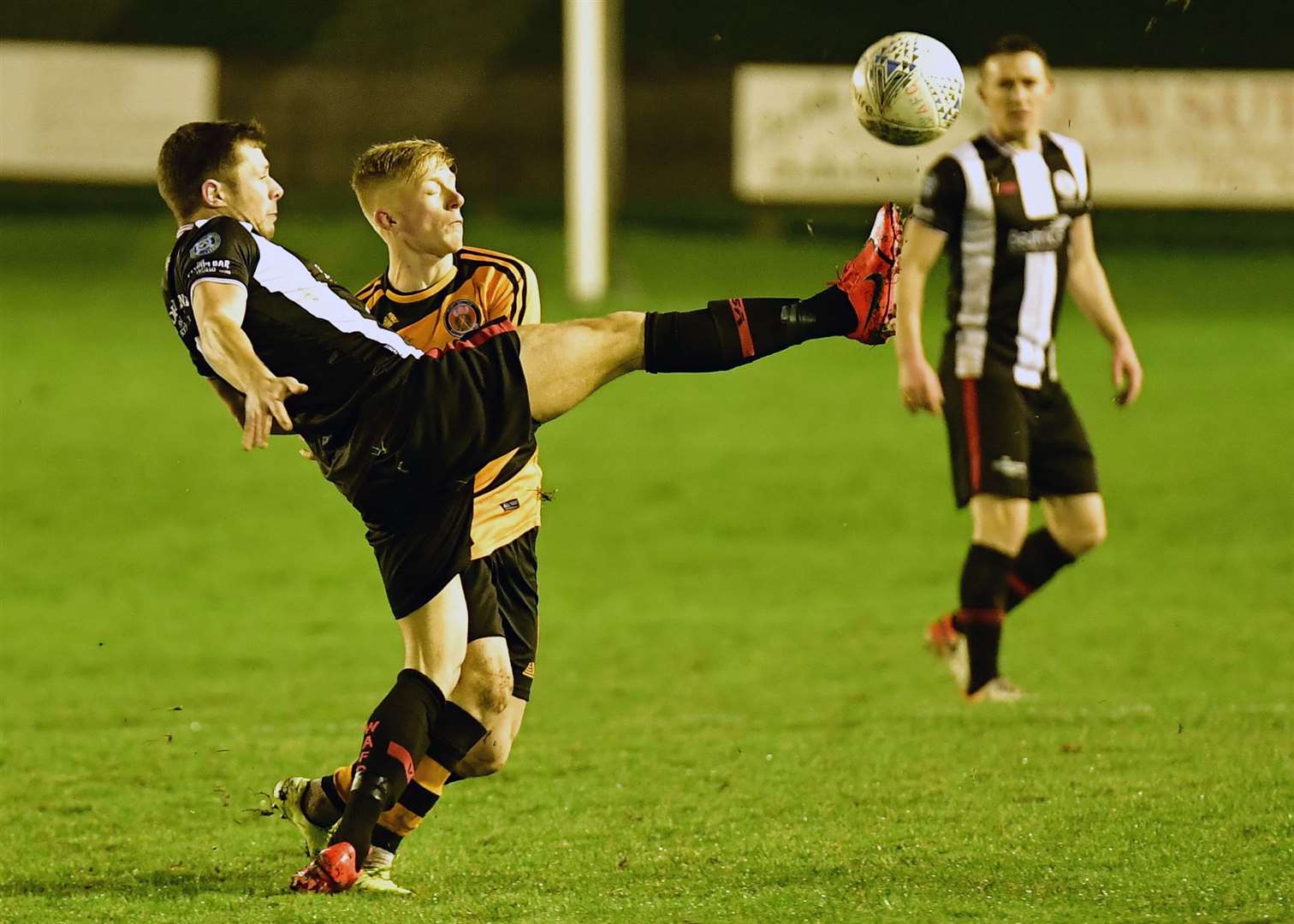 Jack Henry of Wick Academy at full strength to reach the ball ahead of Fort William's Ross Gunn. Picture: Mel Roger