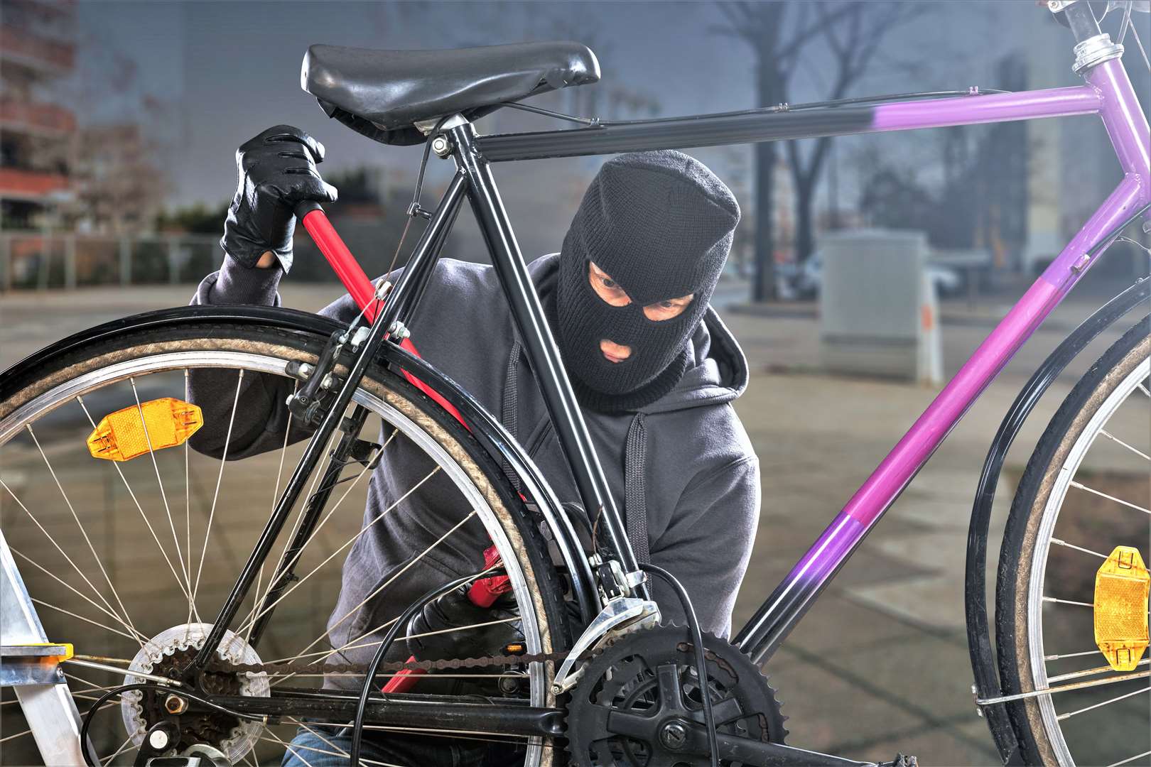 Thief trying to break a bicycle lock.