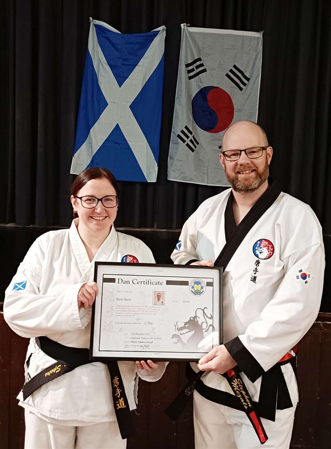 Kerry Speirs being presented with her black belt certificate by Stephen Mezals.