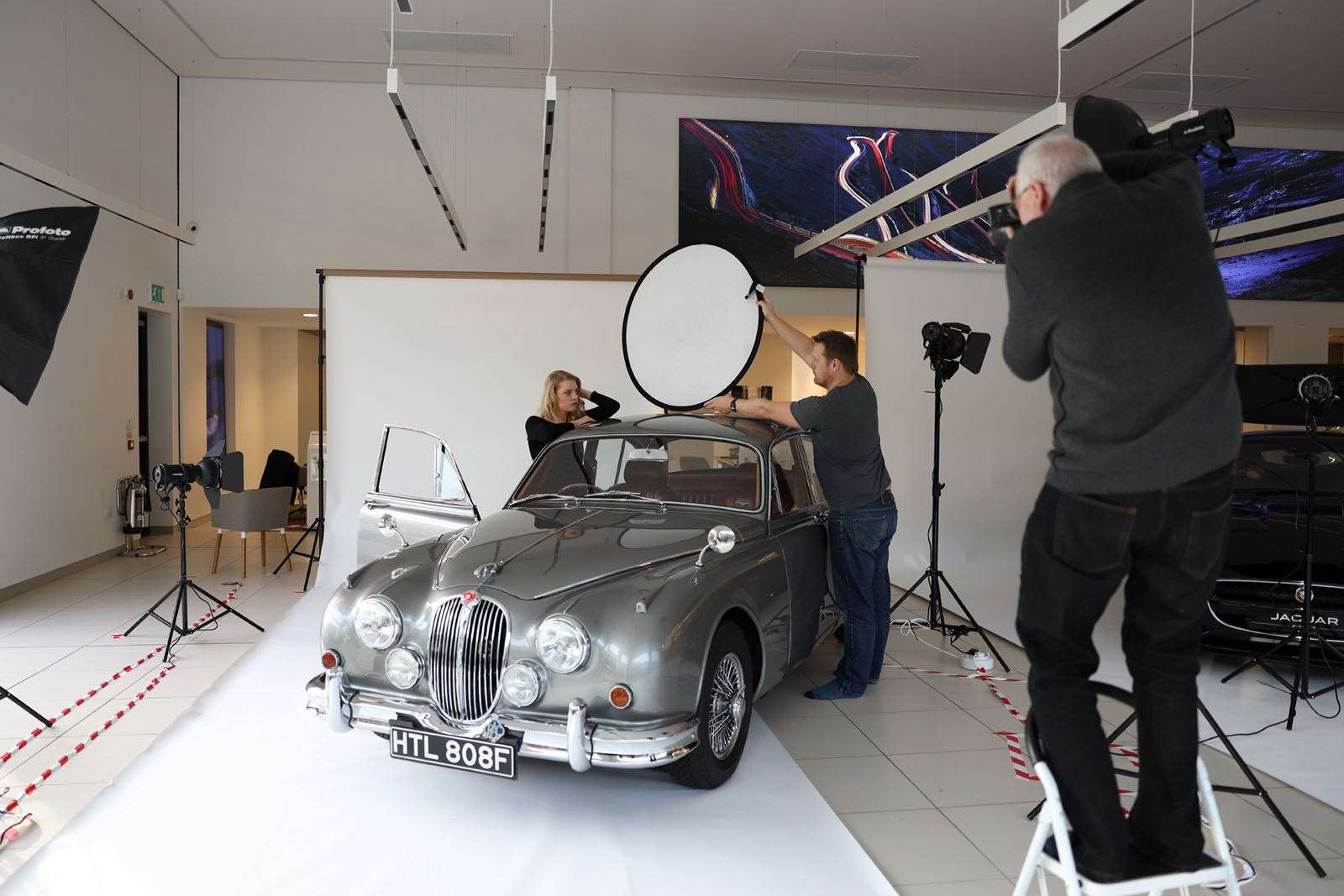 Top Gear's Rod Fountain holds up a reflector to professional model Michaela as James Gunn takes a picture. Picture: Owen Cochrane