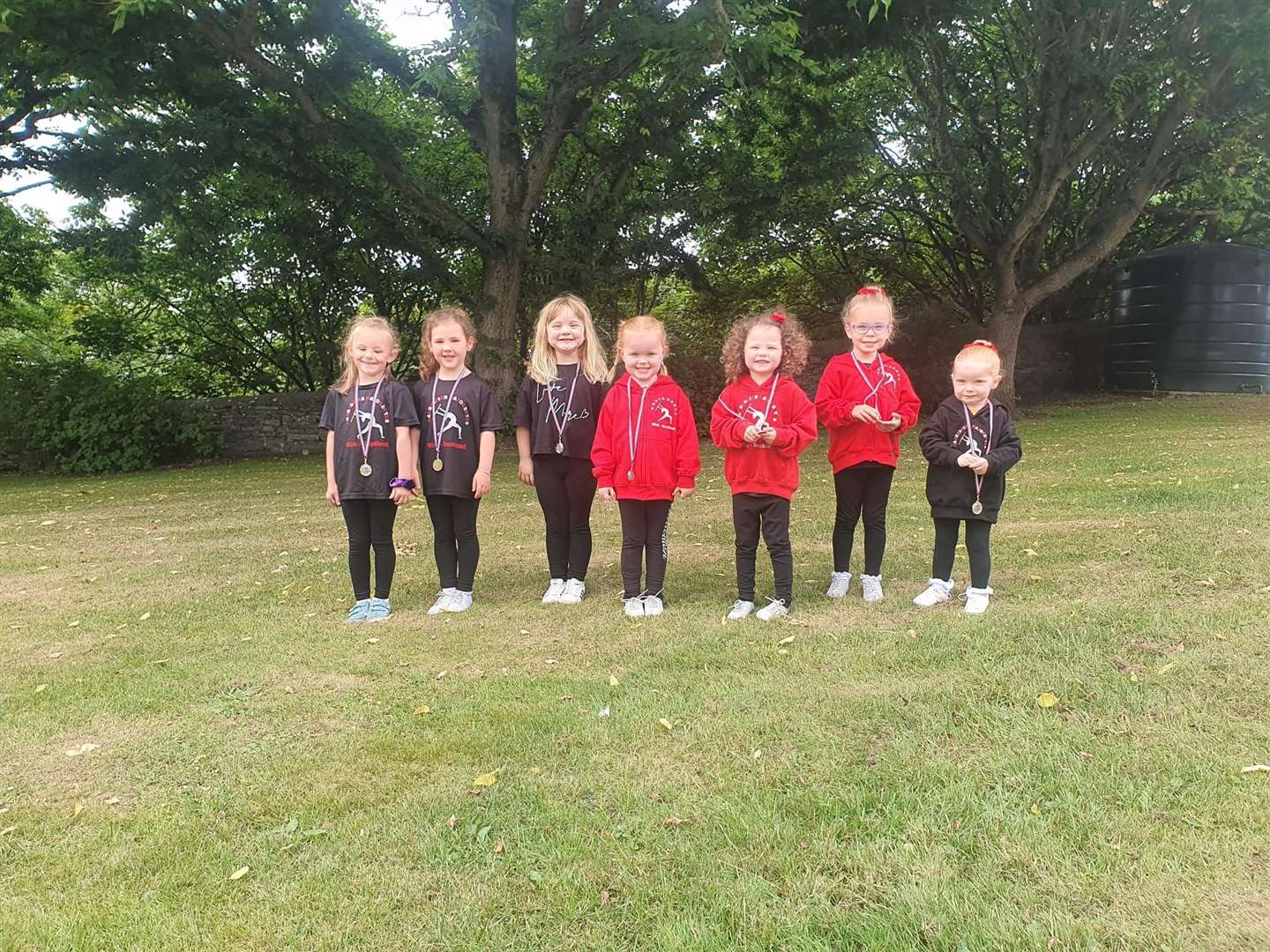 The youngest majorettes proudly display their gala medals.