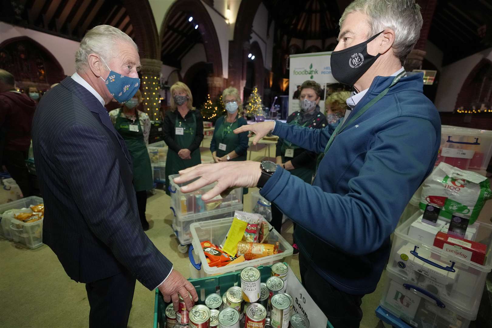 Charles speaks to a volunteer during his tour of the foodbank (Kirsty Wigglesworth/PA)