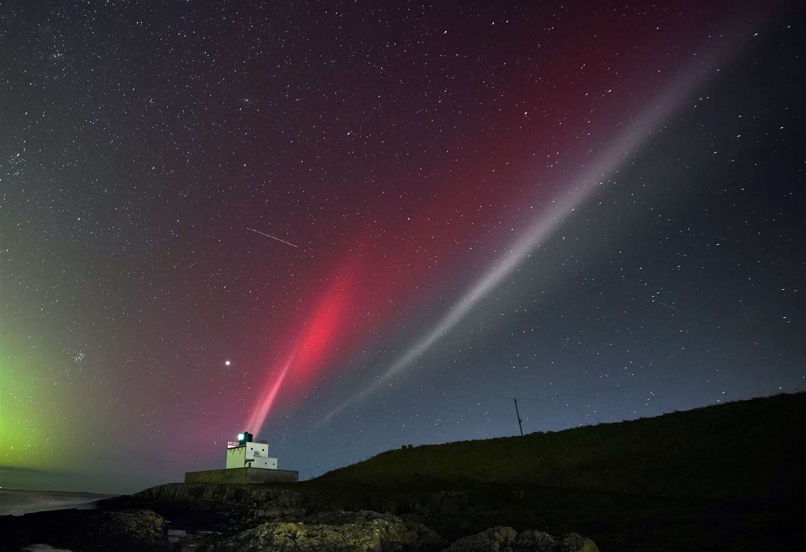 A strong thermal emission velocity enhancement, a rare aurora-like phenomenon named a STEVE in 2016 by scientists in Canada, can be seen over Bamburgh castle, in Northumberland (Owen Humphreys/PA)