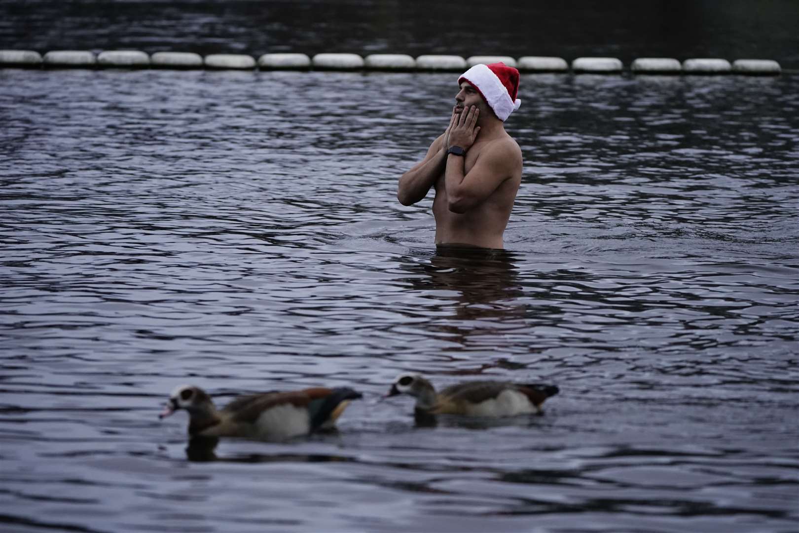 Ducks watched as one man paused during his swim in the Serpentine in Hyde Park, ahead of the annual Peter Pan Cup race that is held every December 25 (Aaron Chown/PA)