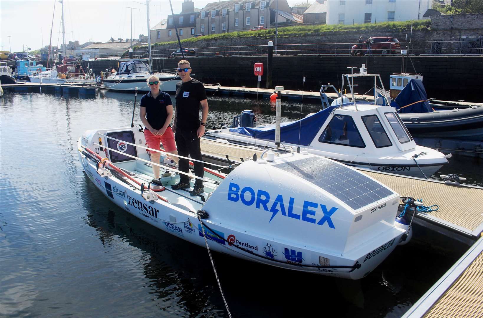 Mhairi Ross and Allan Lipp with their carbon-fibre boat in Wick harbour. Picture: Alan Hendry