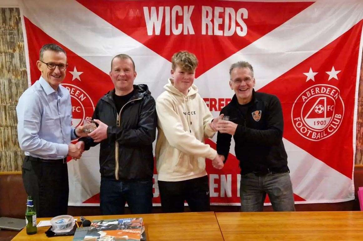 Brian Irvine (left) and Theo ten Caat (right) handing over commemorative glasses to Michael and Luke Wilson from MLG Electrical.
