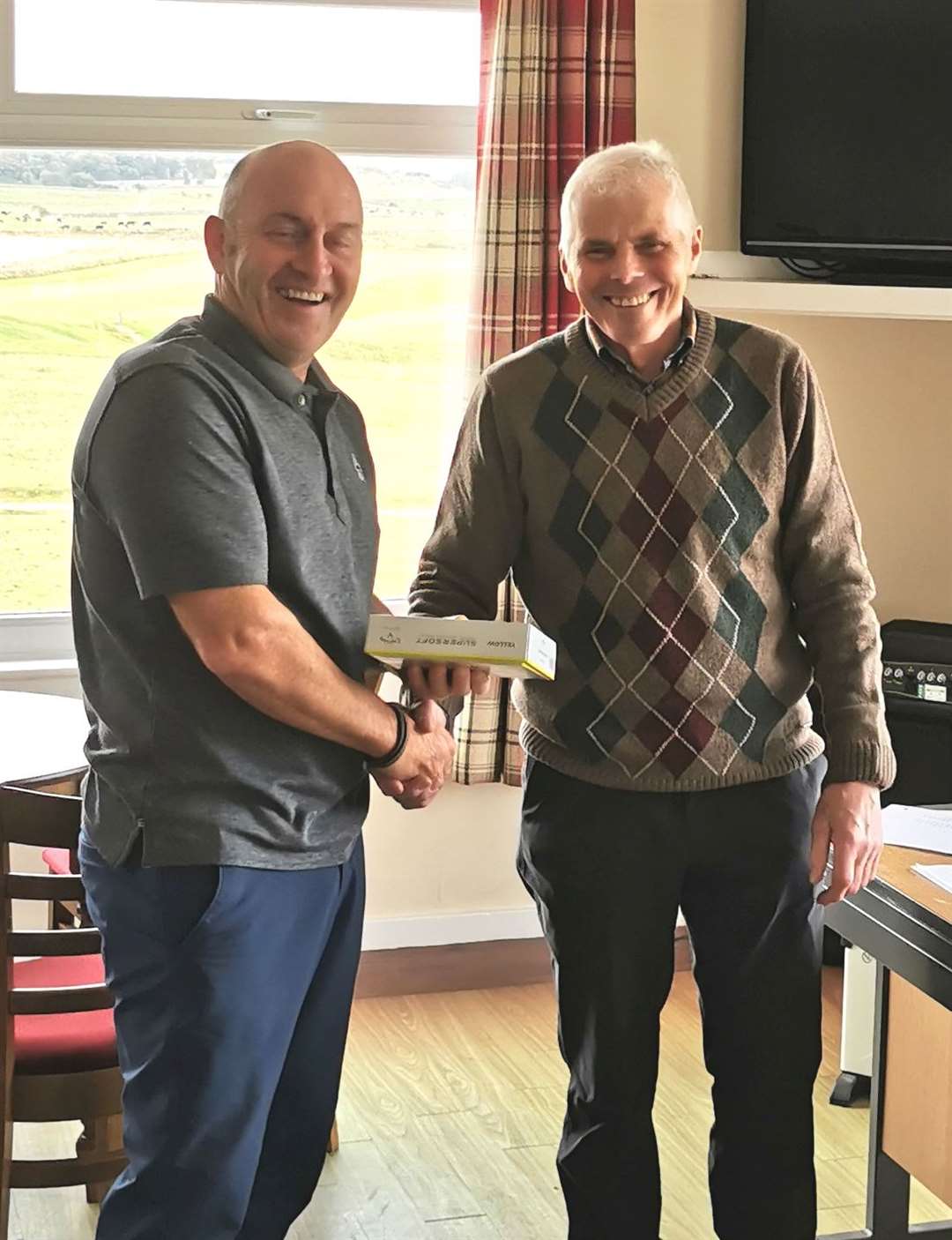 Willie Steven receives the runner-up prize for the North Point Distillery Senior Stableford competition from Sandy Chisholm.