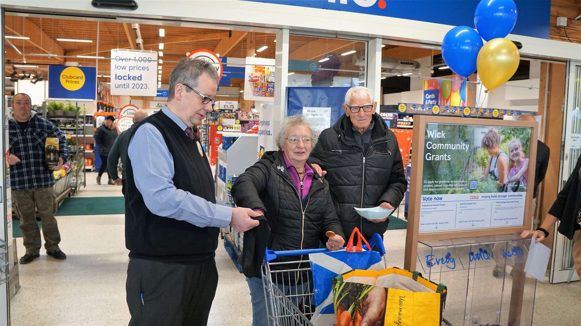 Jane McCarthy from Bower puts her hand in the bag to try and find the elusive golden token. On the left is Billy Duchart who is Tesco Wick's senior fresh manager and at right is Denny Swanson who was helping at the event. Picture: DGS