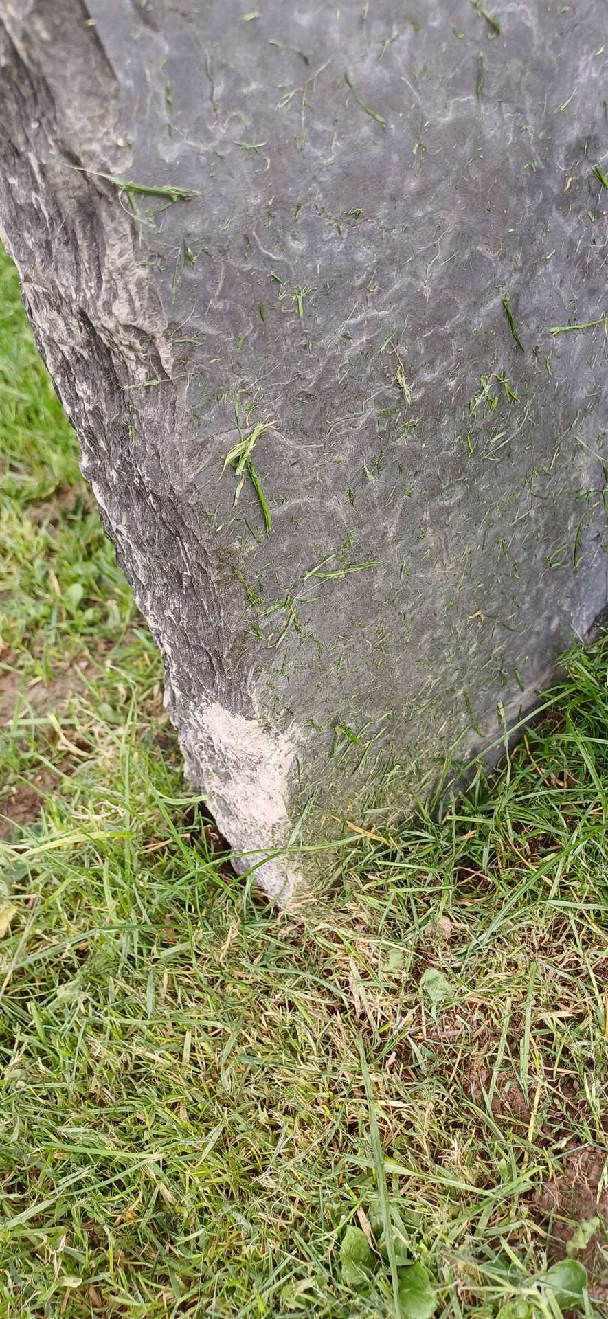 The damage to the gravestone.