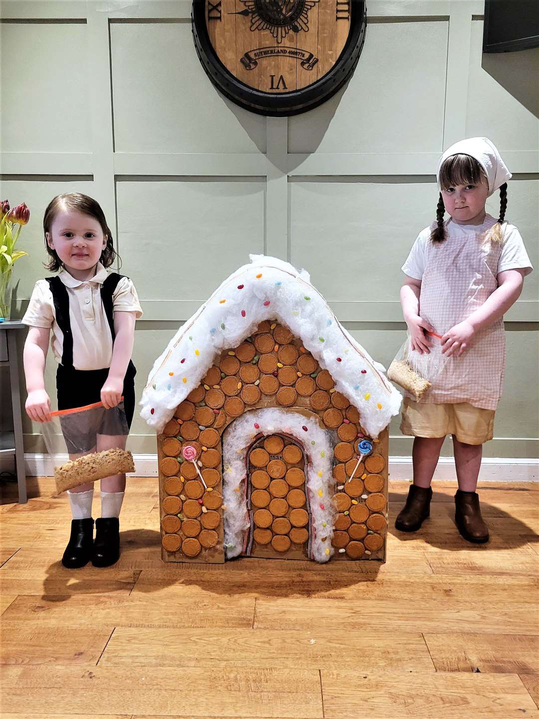 Molly (3) and Sophie (6) enjoy World Book Day playing Hansel and Gretel at Newton Park Primary, with a special home-made gingerbread house.