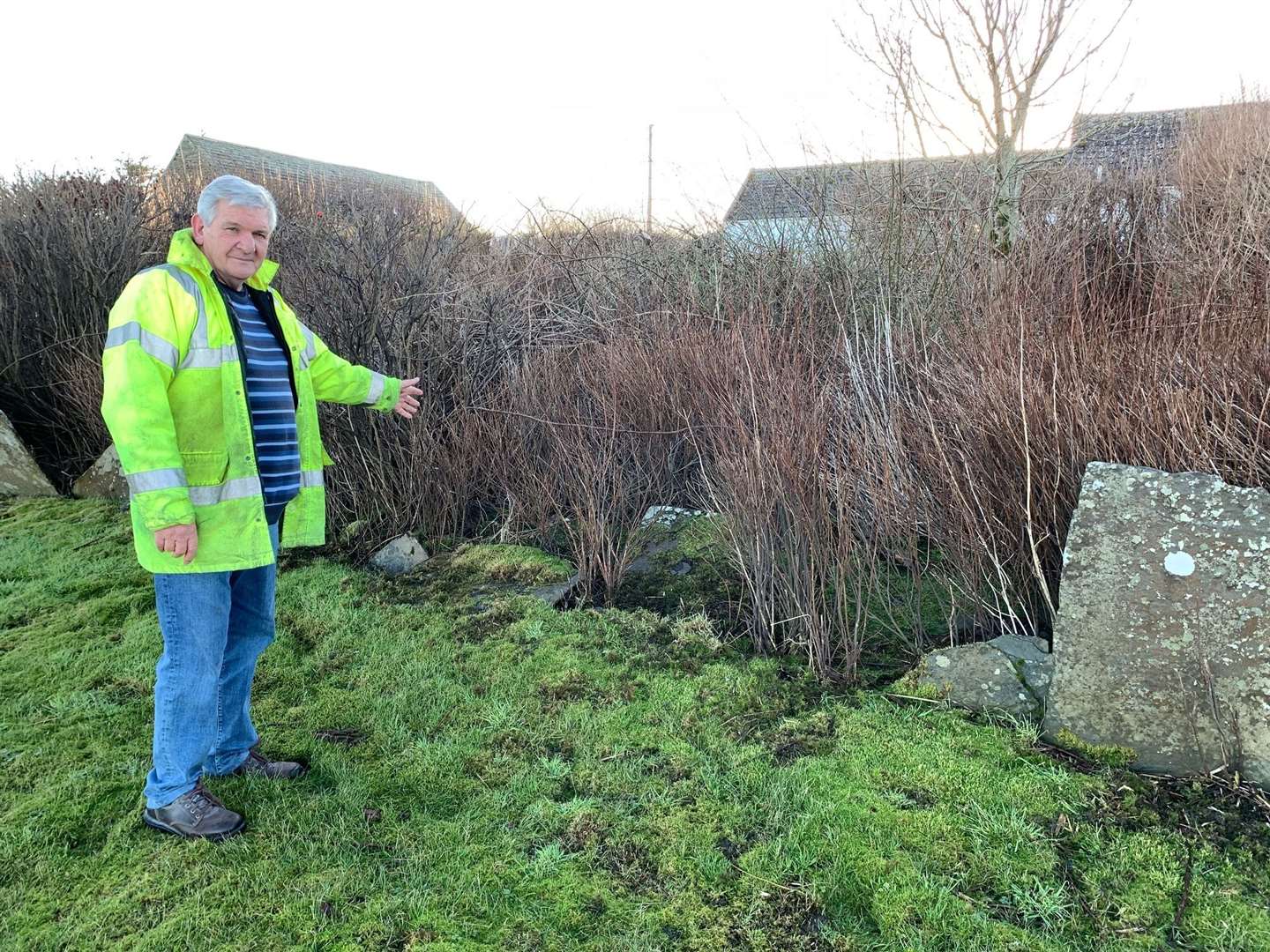 John Crofts beside his flagstone wall which has been struck by vehicles four times in the space of 15 years.