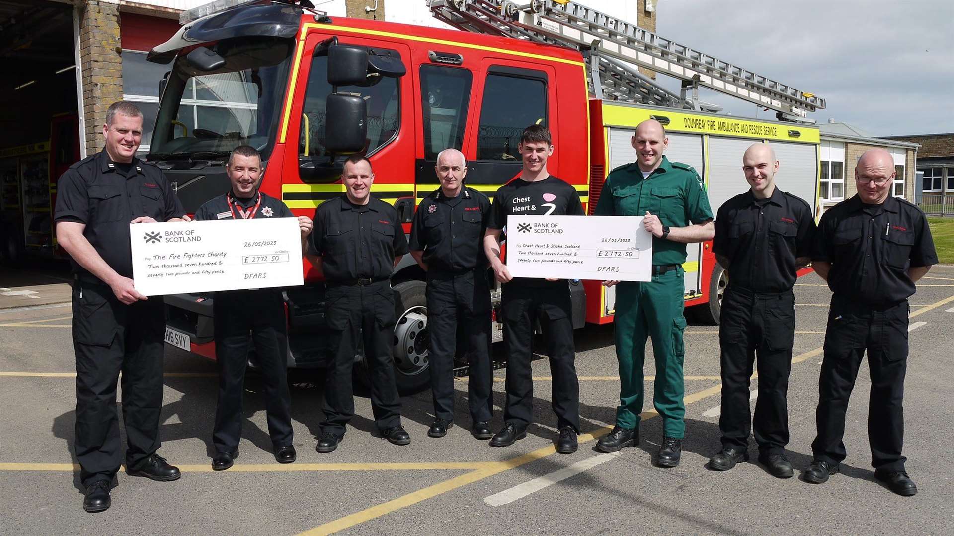 Kevin Oag (left) presents a cheque for £2772.50 to the Fire Fighters Charity representative for the Highlands, Dougie Campbell, while Craig Anderson (third from right) hands a cheque for the same amount to Jake Anderson on behalf of Chest, Heart and Stroke Scotland.