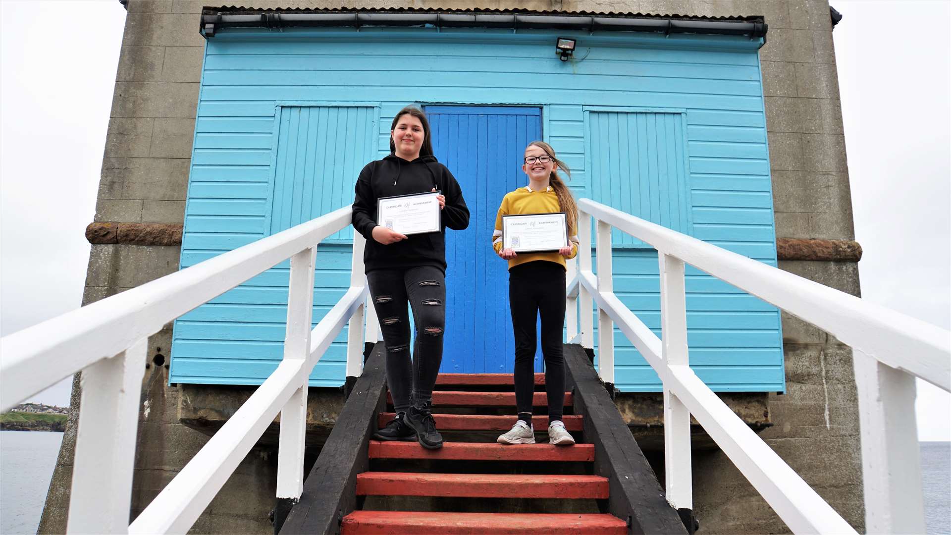 Sarah (left) and Emma with their awards on the steps of Wick's former lifeboat station. Picture: DGS