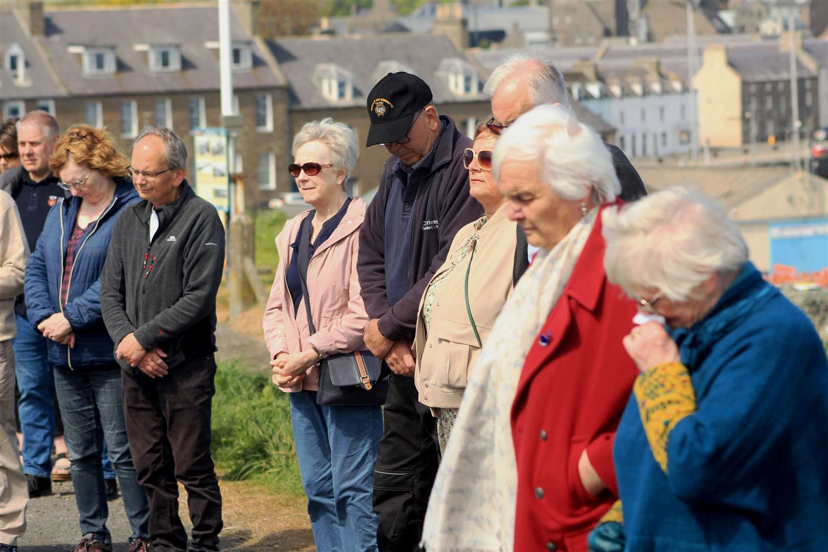 Onlookers reflecting on those who have lost their lives at sea while working in the fishing industry. Picture: Alan Hendry
