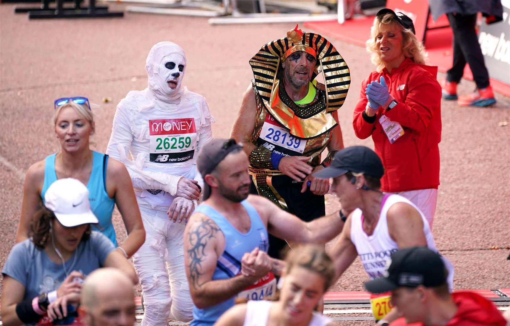 Runners in fancy dress after finishing the Virgin Money London Marathon (Yui Mok/PA)