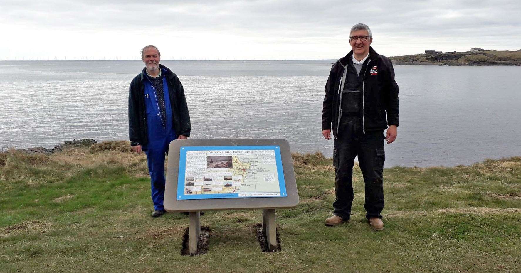David Mackay (left) and Willie Watt with one of the newly installed interpretive panels on Wick's North Head footpath.