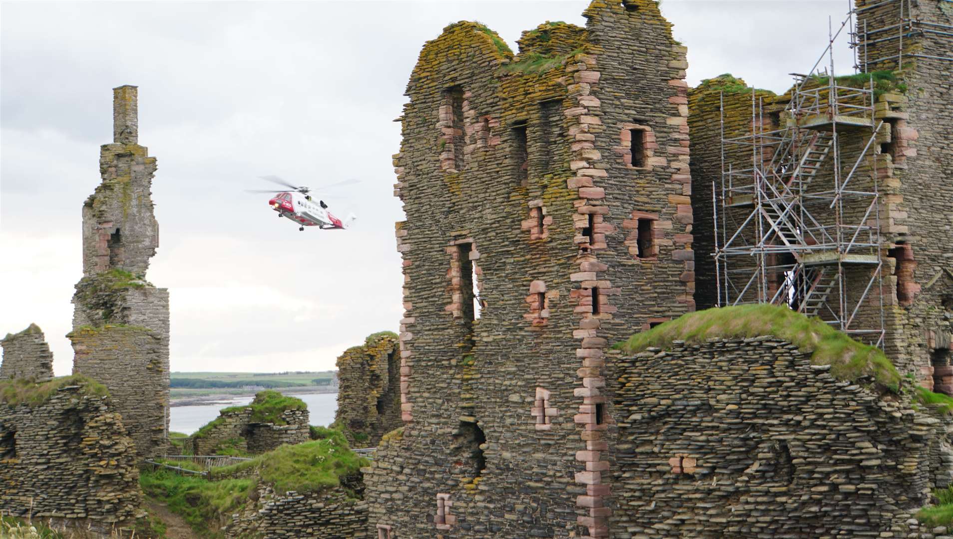 The coastguard helicopter hovers above the injured boy near the ruined castle at Noss Head by Wick. Picture: DGS